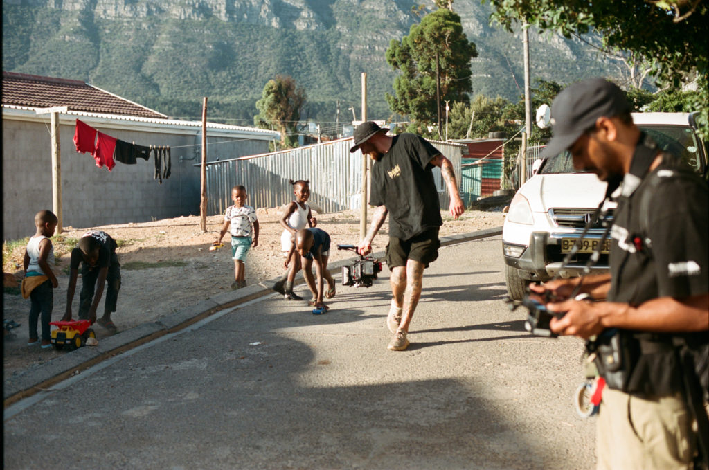analog behind the scenes filmdreh Südafrika für NGO Kameramann rennt straße mit Kindern entlang
