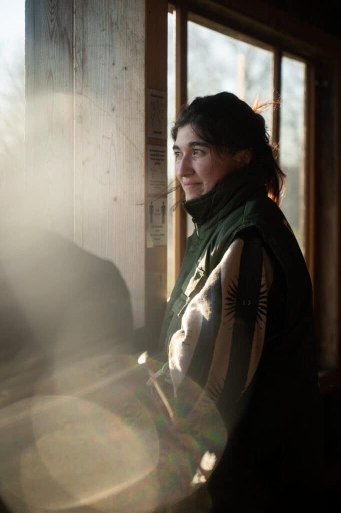 20250328_Kraniche_Boxfish-28 a woman looking out a window