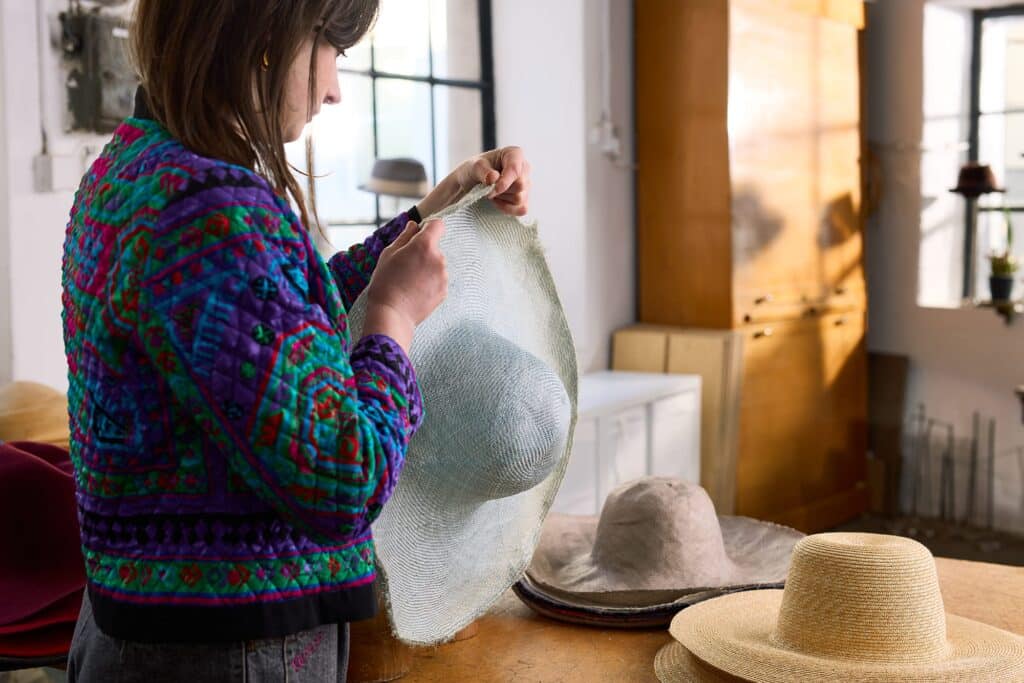 Bernina Nähmaschinen Produktfoto 3 Schneiderin arbeitet mit grauem Strohhut