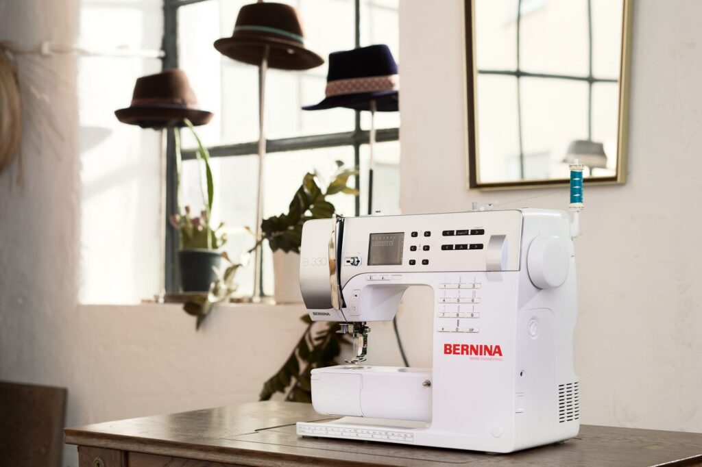 Bernina Nähmaschinen Produktfoto 1 Bernina Nähmaschine auf stisch in hellem raum mit hüten