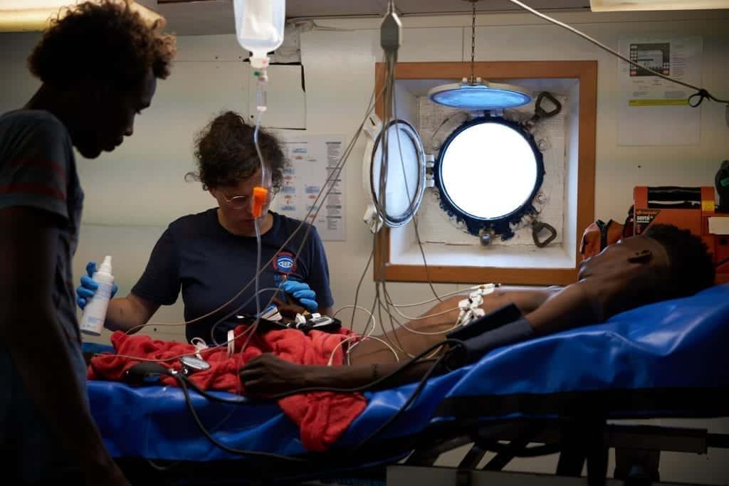 Auf dem Seenotrettungsschiff Alan Kurde der NGO Sea Eye wird ein Flüchtling auf der Krankenstation behandelt, er liegt auf einer Trage